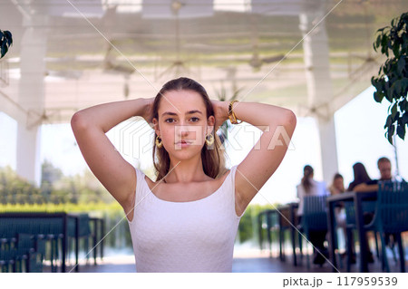 a    portrait of  16-year-old teenage girl in old money style clothes in  fancy restaurant 117959539