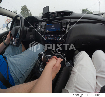 Couple Holding Hands in a Car on a Rainy Day 117960050