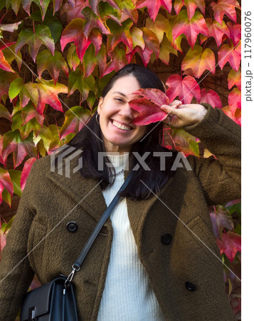 Stylish Woman in Autumn Foliage 117960076