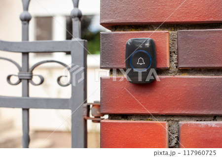 Close-Up of Hand Pressing a Wireless Doorbell 117960725