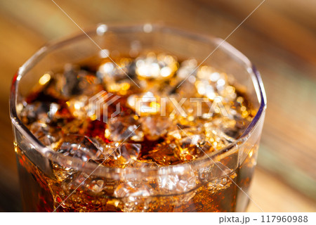 Cola and whiskey in a glass with ice cubes close-up 117960988