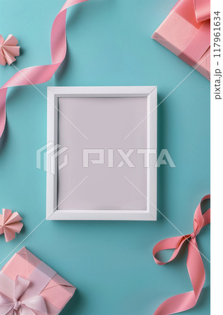 A white frame with a pink ribbon sits on a blue background A white frame with a pink ribbon sits on a blue background 117961634