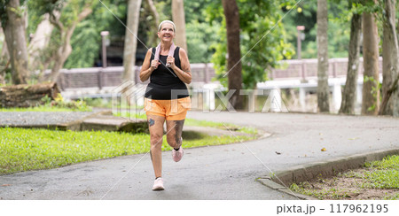 Active senior woman running in green park environment Active senior woman running in green park environment 117962195