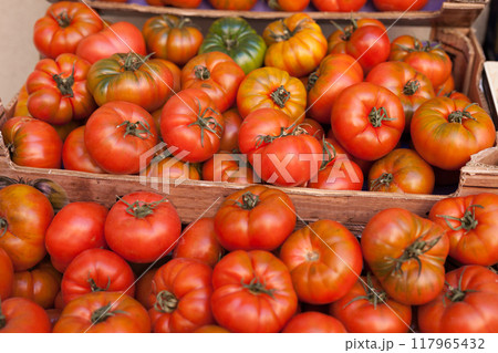 Fresh tomatoes on branch in wicker baskets on counter Fresh tomatoes on branch in wicker baskets on counter 117965432