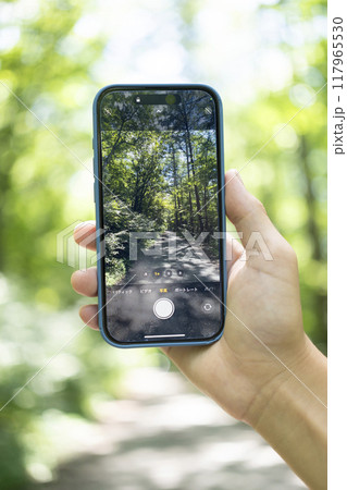 山道をスマホで撮影する手元 117965530