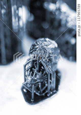 Model of head printed on a 3D printer from black rubber, close-up. Part of an object created on a 3D printer from hardened rubber under the influence of ultraviolet light. SLA 3D printing technology. 117965789