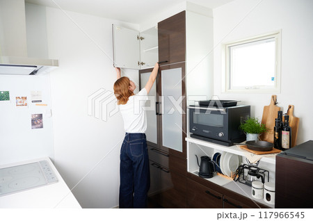 食器棚をあける女性　主婦　家事　料理　片付け 117966545