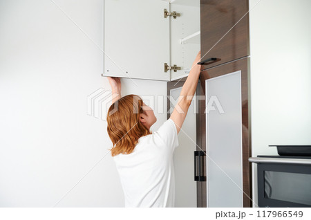 食器棚をあける女性　主婦　家事　料理　片付け 117966549