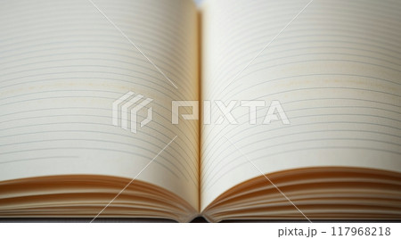 An open notebook rests on a wooden table, ready for thoughts and ideas on a quiet afternoon An open notebook rests on a wooden table, ready for thoughts and ideas on a quiet afternoon 117968218