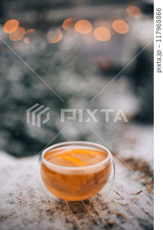 Enjoying warm lemon tea in a cozy winter setting with frosty surroundings and a tranquil atmosphere 117968866