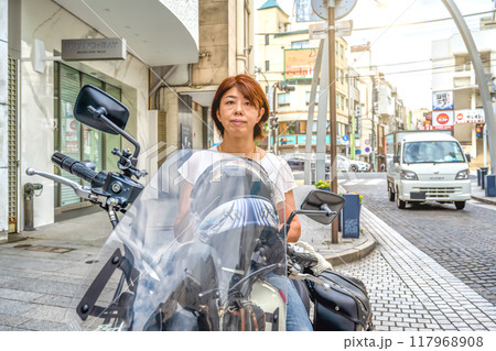 大型アメリカンバイクに乗って横浜元町ショッピングストリートに来た女性ライダー 117968908