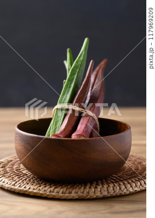 Fresh green and red okra in wooden bowl, Organic vegetable, Food ingredient 117969209
