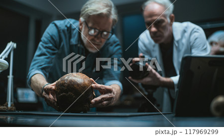 Two archaeologists set up professional camera to photograph fossil remains 117969299