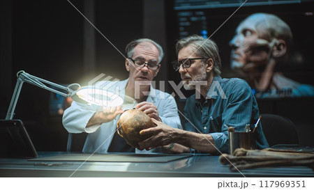 Two archaeologists study fossil remains, use tablet computer Two archaeologists study fossil remains, use tablet computer 117969351