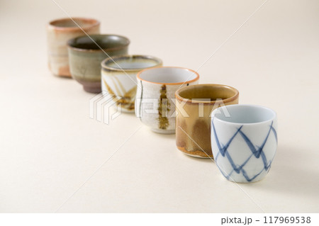 薄金色の背景紙に数種類の酒用おちょこ 117969538