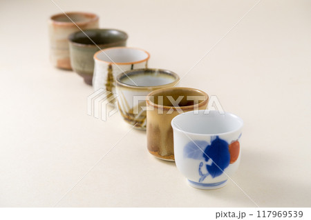 薄金色の背景紙に数種類の酒用おちょこ 薄金色の背景紙に数種類の酒用おちょこ 117969539