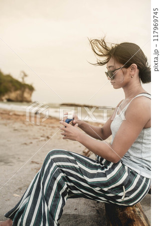 海辺でスキンケアする若い日本人女性 117969745