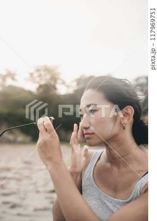 海辺でスキンケアする若い日本人女性 117969751