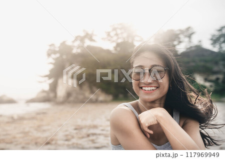 風が強い砂浜でサングラスをかけている若い日本人女性 風が強い砂浜でサングラスをかけている若い日本人女性 117969949