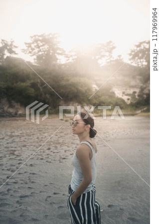 風が強い砂浜でサングラスをかけている若い日本人女性 風が強い砂浜でサングラスをかけている若い日本人女性 117969964
