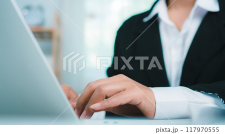 Businesswoman working on laptop computer at office, Hands touch on tablet at office with dark background, Online working, Copy space, Surfing the net, Searching the information, Online working at home Businesswoman working on laptop computer at office, Hands touch on tablet at office with dark background, Online working, Copy space, Surfing the net, Searching the information, Online working at home 117970555