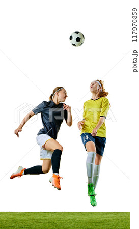 Two athletic women, mid-20s, soccer players, focused on ball mid-air, each positioning themselves to gain control on soccer field. Two athletic women, mid-20s, soccer players, focused on ball mid-air, each positioning themselves to gain control on soccer field. 117970859