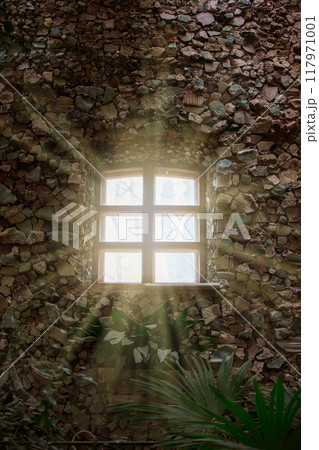 Rays of sunlight from the windows of an ancient stone building. 117971001