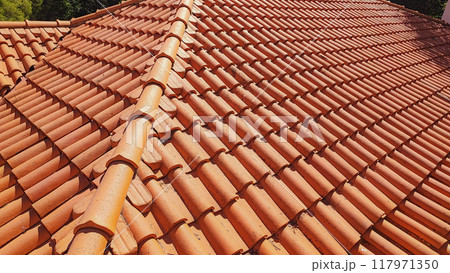 Clay tile roof. Banner with orange clay tile roof close-up on blue sky background with space for text, copy space. 117971350