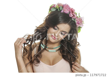 Smiling summer woman with long dark wavy hair, clean shiny skin and pink flower crown Smiling summer woman with long dark wavy hair, clean shiny skin and pink flower crown 117971722
