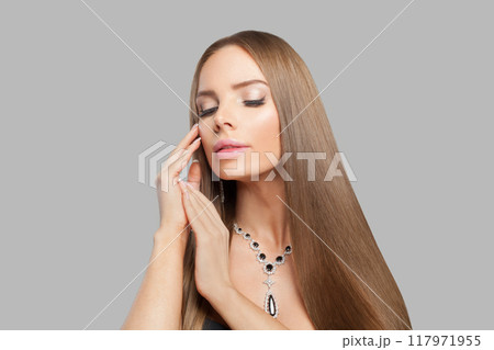 Glad jewelry woman with long healthy hair wearing glamour jewellery necklace.  117971955