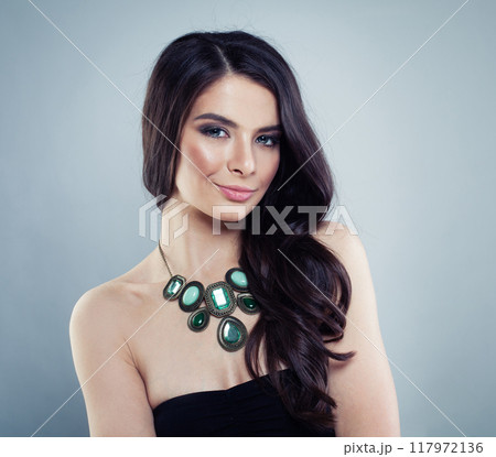 Lovely model brunette with long curled hair and jewelry necklace, fashion beauty studio portrait 117972136