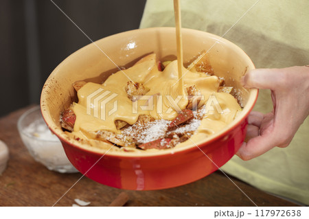 Pour the dough over the apples. Cooking apple pie. Pour the dough over the apples. Cooking apple pie. 117972638