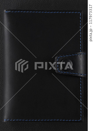 Black leather wallet with blue stitching on a black background. Black leather wallet with blue stitching on a black background. 117973317