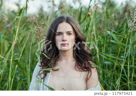 Gorgeous healthy brunette woman with long hairstyle and fresh skin walking outdoors 117973421
