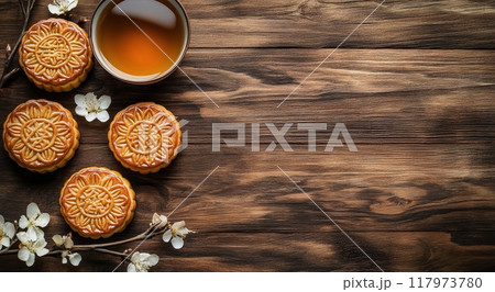 Warm tea and mooncakes on a wooden table decorated with delicate cherry blossoms in spring 117973780