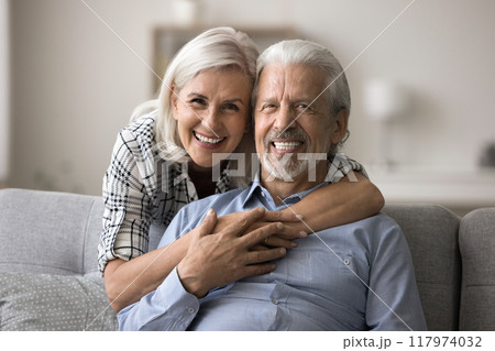 Cheerful mature spouses posing for camera, home portrait 117974032