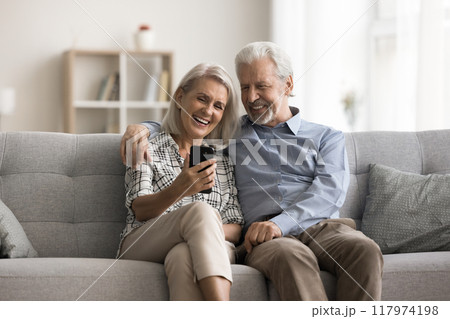 Older spouses using smartphone laughing, watching funny videos Older spouses using smartphone laughing, watching funny videos 117974198