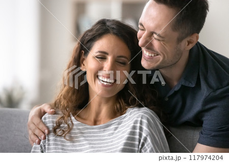 Cheerful husband hugs beautiful wife, joking, giggling, feel happy 117974204