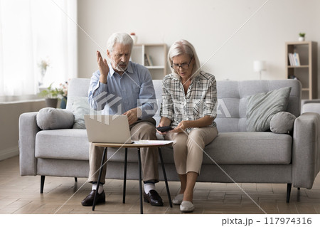 Older husband and wife calculating domestic expenditures Older husband and wife calculating domestic expenditures 117974316