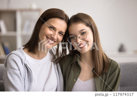 Smiling mother and teen daughter posing for camera Smiling mother and teen daughter posing for camera 117974317