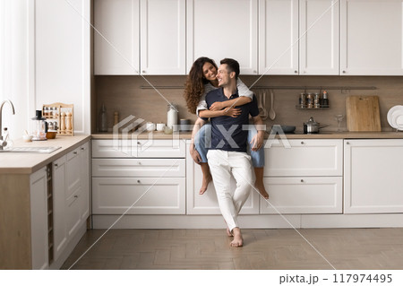 Wife cuddling husband, enjoy talk in good furnished kitchen Wife cuddling husband, enjoy talk in good furnished kitchen 117974495