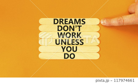 Dream and do symbol. Wooden blocks with words Dreams do not work unless you do. Beautiful orange table, orange background, copy space. Businessman hand. Business, motivational dream and do concept. 117974661
