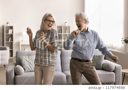 Happy retired couple dancing in cozy living room 117974698