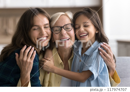 Happy sweet loving granddaughter kid and young mom hugging grandma Happy sweet loving granddaughter kid and young mom hugging grandma 117974707