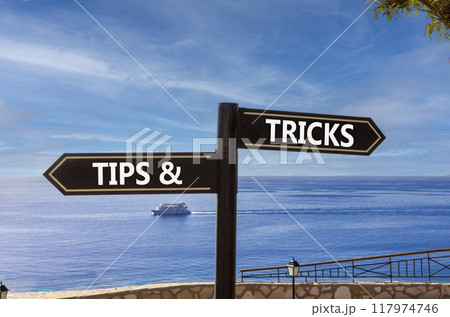 Tips and tricks symbol. Concept word Tips and tricks on beautiful signpost with two arrows. Beautiful blue sea sky with clouds background. Business and Tips and tricks concept. Copy space. Tips and tricks symbol. Concept word Tips and tricks on beautiful signpost with two arrows. Beautiful blue sea sky with clouds background. Business and Tips and tricks concept. Copy space. 117974746
