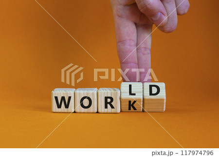 World and work symbol. Businessman turns wooden cubes and changes the word 'work' to 'world'. Beautiful orange table, orange background, copy space. Business, world and work concept. 117974796