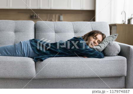 Calm asleep tired young woman lying on belly on couch 117974887