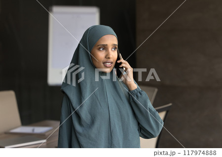Serious beautiful young Arab manager woman talking on mobile phone Serious beautiful young Arab manager woman talking on mobile phone 117974888
