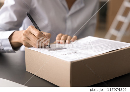 Cropped closeup shot unknown businesswoman labeling or signing package box 117974893