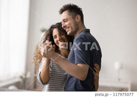 Overjoyed couple in love dancing at home Overjoyed couple in love dancing at home 117975077
